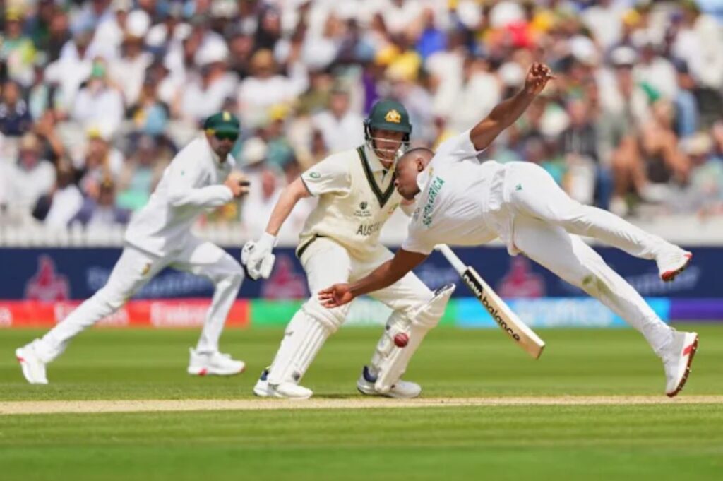 South African fast bowler diving to stop the ball as Australian batsman looks on during WTC Final 2025 at Lord’s