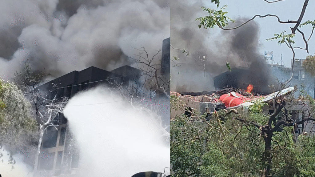 Burnt fuselage and scattered aircraft parts in a residential Indian neighborhood